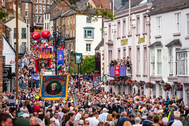 Crowds pass under the balcony of the County Hotel and along Old Elvet at the 2019 Durham Miners' Gala.