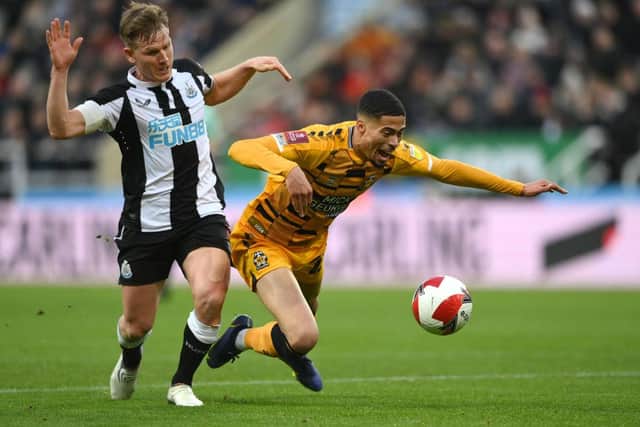 Harvey Knibbs of Cambridge United is challenged by Matt Ritchie of Newcastle United during the Emirates FA Cup Third Round match between Newcastle United and Cambridge United at St James' Park on January 08, 2022 in Newcastle upon Tyne, England. (Photo by Stu Forster/Getty Images)