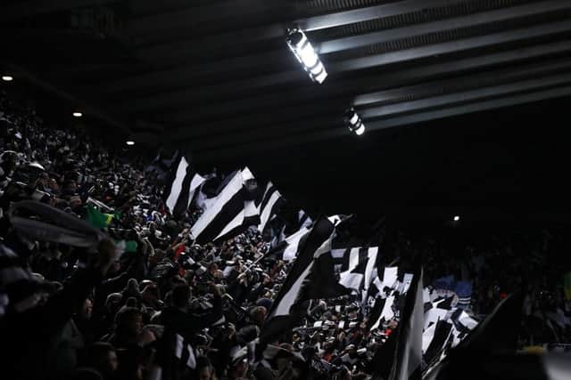 Newcastle United fans wave scarves and flags before the game.