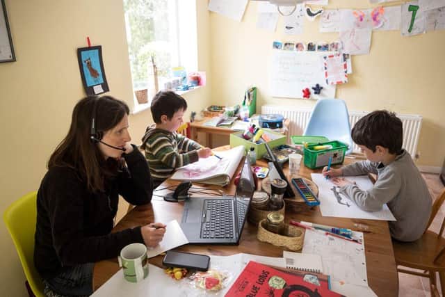 Six-year-old Leo (R) and his three-year old brother Espen (C) complete homeschooling activities suggested by the online learning website of their infant school, as his mother Moira, an employee of a regional council, works from home during the novel coronavirus COVID-19 pandemic. (Photo by OLI SCARFF/AFP via Getty Images)