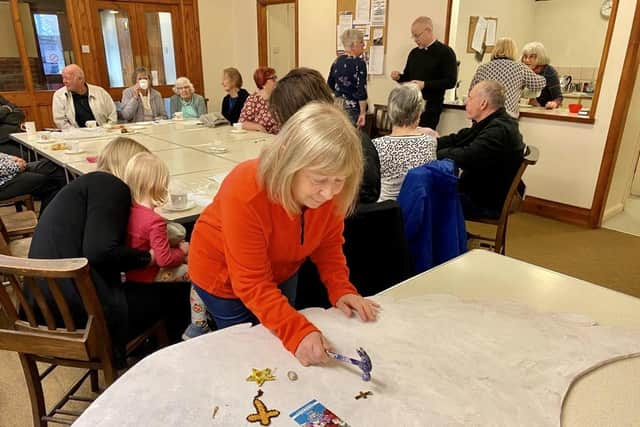 Sue Bates at a coffee morning attaching a treasured item to the wings.