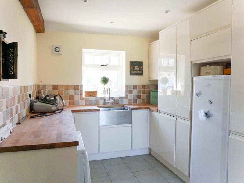 Utility room with a range of fitted cupboards and cloakroom with WC.