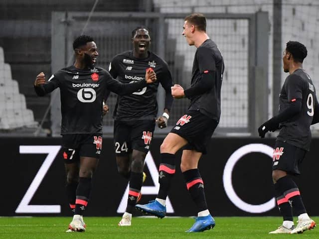 Lille's Dutch defender Sven Botman (2nd R) celebrates with Lille's French midfielder Jonathan Bamba (L), Lille's Belgian midfielder Amadou Onana (2nd L) and Lille's Canadian forward Jonathan David (R) after scoring a goal during the French L1 football match between Olympique Marseille (OM) and Lille OSC at the Velodrome Stadium in Marseille, southern France, on January 16, 2022. (Photo by SYLVAIN THOMAS/AFP via Getty Images)