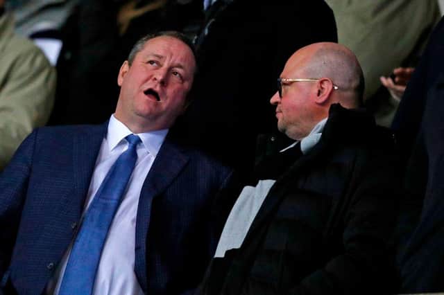 Newcastle United's English owner Mike Ashley (L) chats with director Lee Charnley (R) in the crowd ahead of the FA Cup fourth round replay football match between Oxford United and Newcastle United at the Kassam Stadium in Oxford, west of London, on February 4, 2020.