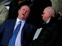 Newcastle United's English owner Mike Ashley (L) chats with director Lee Charnley (R) in the crowd ahead of the FA Cup fourth round replay football match between Oxford United and Newcastle United at the Kassam Stadium in Oxford, west of London, on February 4, 2020.