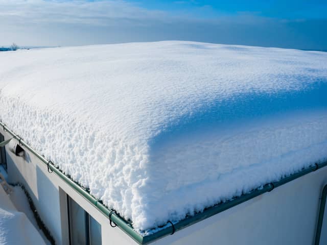 Heavy snow on a flat roof can cause structural damage.