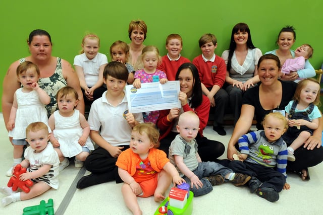 A cheque handover to a parent and toddler group from children who took part in the Smile Challenge in 2013 but who can tell us where this is?
