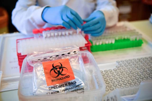 Lab technicians handle suspected COVID-19 samples as they carry out a diagnostic test for coronavirus. Picture by Ben Birchall/PA Wire