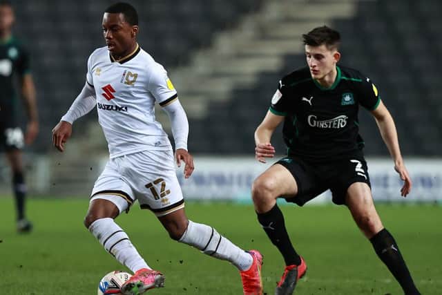 Ethan Laird of Milton Keynes Dons moves away from Kelland Watts during the Sky Bet League One match between Milton Keynes Dons and Plymouth Argyle.
