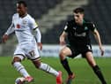 Ethan Laird of Milton Keynes Dons moves away from Kelland Watts during the Sky Bet League One match between Milton Keynes Dons and Plymouth Argyle.