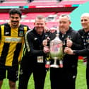 Hebburn Town manager Kevin Bolam (second right) celebrates with Angelos Eleftheriadis (left), coaches Michael Mulhern and Jason Miller (right) with the Buildbase FA Vase 2019/20 Trophy after victory in the Final at Wembley Stadium.