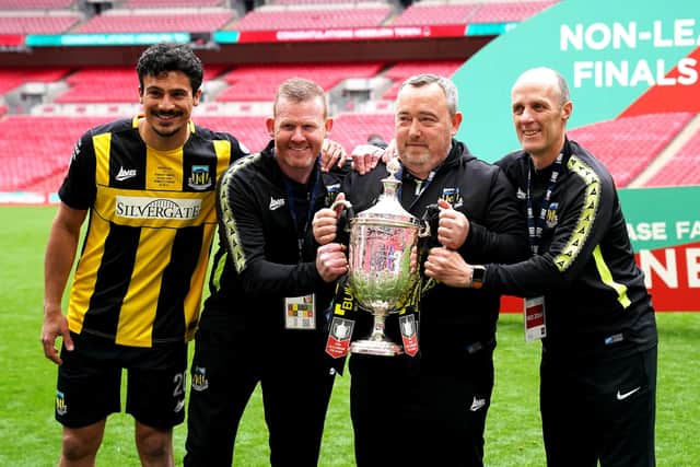 Hebburn Town manager Kevin Bolam (second right) celebrates with Angelos Eleftheriadis (left), coaches Michael Mulhern and Jason Miller (right) with the Buildbase FA Vase 2019/20 Trophy after victory in the Final at Wembley Stadium.