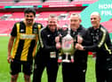 Hebburn Town manager Kevin Bolam (second right) celebrates with Angelos Eleftheriadis (left), coaches Michael Mulhern and Jason Miller (right) with the Buildbase FA Vase 2019/20 Trophy after victory in the Final at Wembley Stadium.