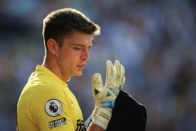 Newcastle United's English goalkeeper Nick Pope looks at his gloves during the English Premier League football match between Newcastle United and Manchester City at St James' Park in Newcastle-upon-Tyne, north east England, on August 21, 2022. (Photo by LINDSEY PARNABY/AFP via Getty Images)