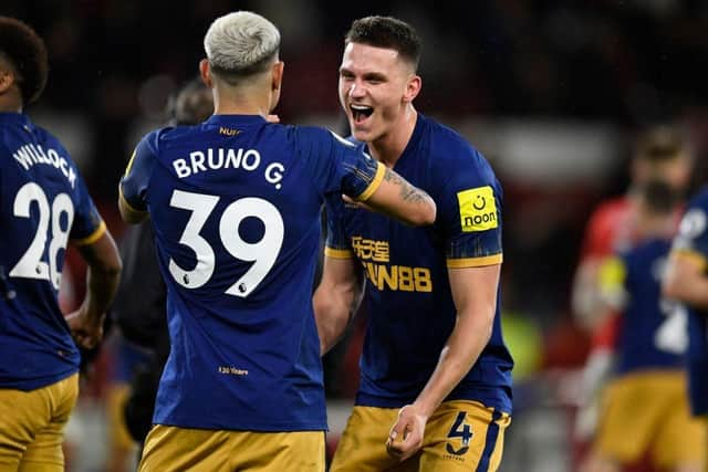 Newcastle United defender Sven Botman celebrates the club's win over Nottingham Forest with midfielder Bruno Guimaraes.