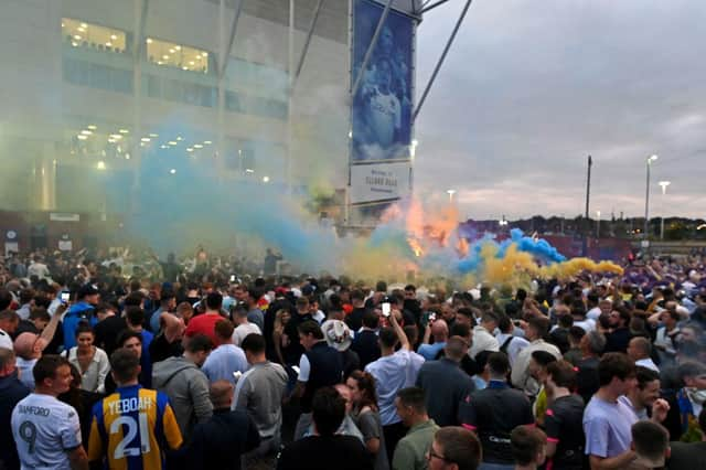 Leeds United supporters gather outside their Elland Road ground to celebrate the club's return to the Premier League after a gap of 16 years, in Leeds, northern England on July 17, 2020. - Leeds United were promoted to the Premier League on Friday after West Bromwich Albion's 2-1 defeat at Huddersfield ensured the Championship leaders will end their 16-year exile from the top-flight.