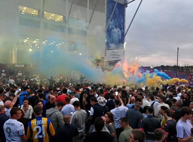 Leeds United supporters gather outside their Elland Road ground to celebrate the club's return to the Premier League after a gap of 16 years, in Leeds, northern England on July 17, 2020. - Leeds United were promoted to the Premier League on Friday after West Bromwich Albion's 2-1 defeat at Huddersfield ensured the Championship leaders will end their 16-year exile from the top-flight.