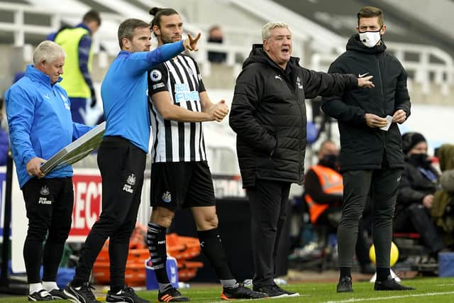 Newcastle United's Andy Carroll gets ready to go on as manager Steve Bruce intructs his players.