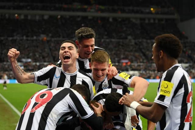 Dan Burn, not pictured, is mobbed by his Newcastle United team-mates after opening the scoring.