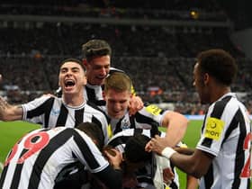 Dan Burn, not pictured, is mobbed by his Newcastle United team-mates after opening the scoring.
