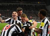 Dan Burn, not pictured, is mobbed by his Newcastle United team-mates after opening the scoring.