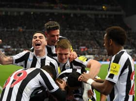 Dan Burn, not pictured, is mobbed by his Newcastle United team-mates after opening the scoring.