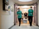 Pharmacists transport a cooler containing the Moderna vaccine, at the West Wales General Hospital in Carmarthen, the third vaccine to be approved for use in the UK, which is to be given to patients in Wales from Wednesday, April 7.