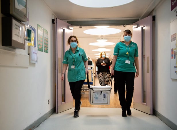 Pharmacists transport a cooler containing the Moderna vaccine, at the West Wales General Hospital in Carmarthen, the third vaccine to be approved for use in the UK, which is to be given to patients in Wales from Wednesday, April 7.