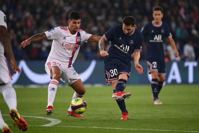 Paris Saint-Germain's Argentinian forward Lionel Messi (C) kicks the ball past Lyon's Brazilian midfielder Bruno Guimaraes during the French L1 football match between Paris-Saint Germain (PSG) and Olympique Lyonnais at The Parc des Princes Stadium in Paris on September 19, 2021. (Photo by FRANCK FIFE / AFP) (Photo by FRANCK FIFE/AFP via Getty Images)