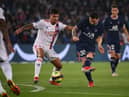 Paris Saint-Germain's Argentinian forward Lionel Messi (C) kicks the ball past Lyon's Brazilian midfielder Bruno Guimaraes during the French L1 football match between Paris-Saint Germain (PSG) and Olympique Lyonnais at The Parc des Princes Stadium in Paris on September 19, 2021. (Photo by FRANCK FIFE / AFP) (Photo by FRANCK FIFE/AFP via Getty Images)