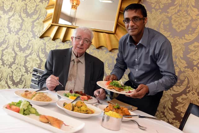 Radhuni owner Kowsar Choudhury and Coun Alan Kerr revealing the menu for Restaurant Week in the borough