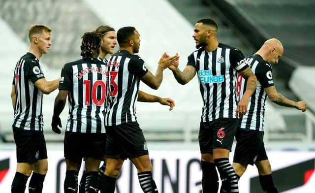 Newcastle United's players celebrate Luke Shaw's own goal.