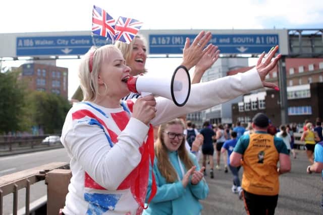 A woman sports a Union Jack outfit as she cheers on those taking part in the Great North Run.