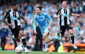 Jack Grealish of Manchester City is challenged by Jamaal Lascelles and Sean Longstaff of Newcastle United during the Premier League match between Manchester City and Newcastle United at Etihad Stadium on May 08, 2022 in Manchester, England. (Photo by Alex Livesey/Getty Images)
