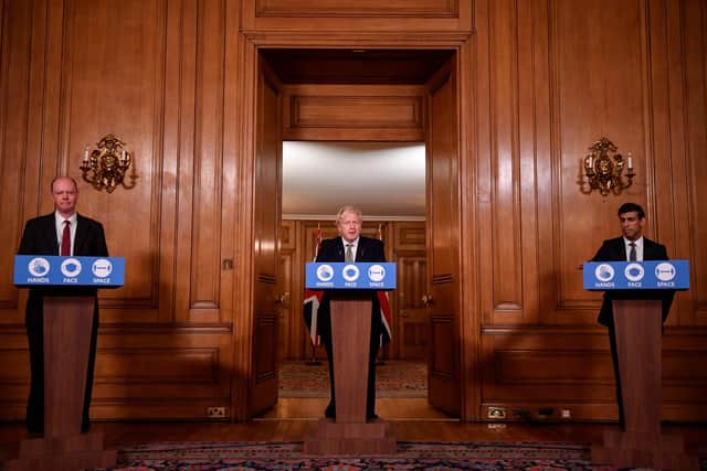 Prime Minister Boris Johnson is flanked by Chief Medical Officer for England, Chris Whitty and Chancellor of the Exchequer, Rishi Sunak (R) during a virtual briefing outlining new Covid-19 rules that are due to be imposed across the nation at Downing Street on October 12. (Photo by Toby Melville - WPA Pool/Getty Images)