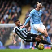Erling Haaland of Manchester City is tackled by Jamaal Lascelles of Newcastle United during the Premier League match between Manchester City and Newcastle United at Etihad Stadium on March 04, 2023 in Manchester, England. (Photo by Laurence Griffiths/Getty Images)