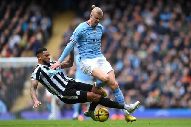 Erling Haaland of Manchester City is tackled by Jamaal Lascelles of Newcastle United during the Premier League match between Manchester City and Newcastle United at Etihad Stadium on March 04, 2023 in Manchester, England. (Photo by Laurence Griffiths/Getty Images)