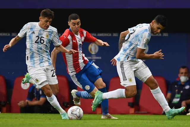 Paraguay's Miguel Almiron vies for the ball with Argentina's Nahuel Molina (L) and Cristian Romero during their Conmebol Copa America 2021 football tournament group phase match at the Mane Garrincha Stadium in Brasilia on June 21, 2021. (Photo by EVARISTO SA / AFP) (Photo by EVARISTO SA/AFP via Getty Images)