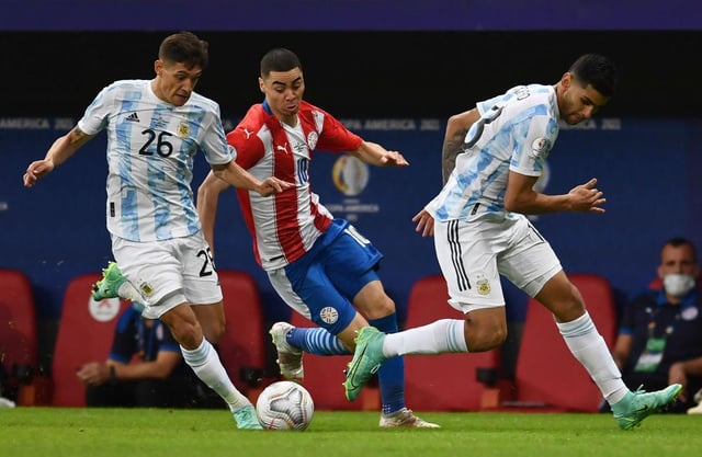 Paraguay's Miguel Almiron vies for the ball with Argentina's Nahuel Molina (L) and Cristian Romero during their Conmebol Copa America 2021 football tournament group phase match at the Mane Garrincha Stadium in Brasilia on June 21, 2021. (Photo by EVARISTO SA / AFP) (Photo by EVARISTO SA/AFP via Getty Images)