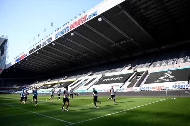 The Newcastle United team warm up in front of empty stands.