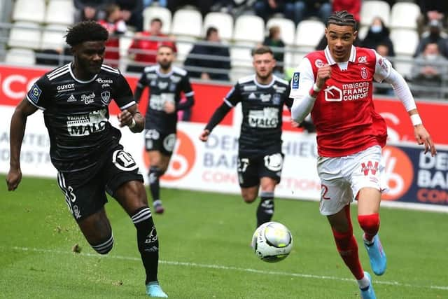 Reims' French forward Hugo Ekitike (R) fights for the ball withBrest's French defender Lilian Brassier (L) during the French L1 football match between Reims and Brest at the Auguste Delaune Stadium in Reims, on February 20, 2022. (Photo by FRANCOIS NASCIMBENI / AFP)