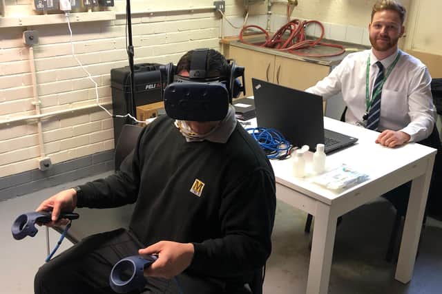 Metro driver Craig Pearson using the VR headset under supervision of Metro Development Officer Alan Dryden