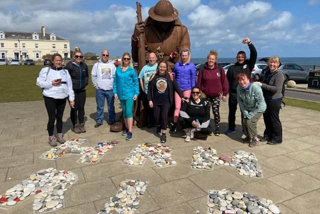 The dozen fundraising walkers stopping by the Seaham Tommy war memorial.