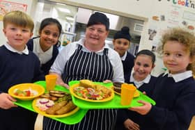 Stanhope Primary School cook Lynn Curtin ahead of International School Meals Day. The pupils pictured are, from left Cody Headley, Bisma Khawaja, Jaspreet Singh, Jessica Paul, and Emily Kouhy.