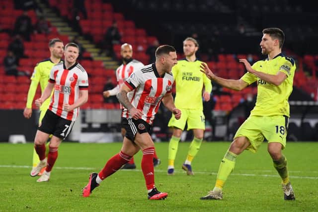 Billy Sharp of Sheffield United (l) clashes with Federico Fernandez after scoring the winning goal from the penalty spot during the Premier League match between Sheffield United and Newcastle United at Bramall Lane on January 12, 2021 in Sheffield, England.