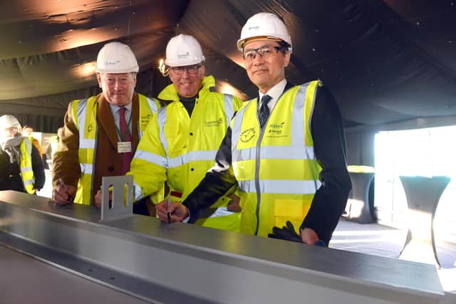 Wates Group chair Sir James Waters, Sunderland Executive Director of City Development Peter McIntyre and CEO Envision Shoichi Matsumoto sign a girder which will form part of the building