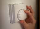 Undated file photo of a person using a central heating thermostat.