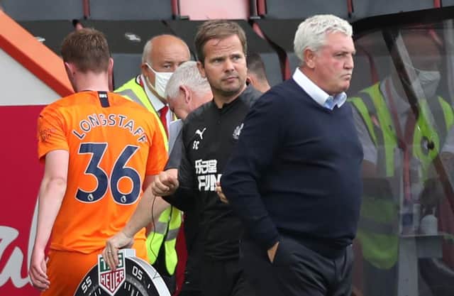 Sean Longstaff leaves the field as Steve Bruce looks on to the pitch.