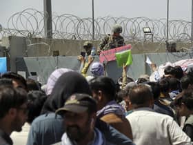 Hundreds of people gathering near an evacuation control checkpoint on the perimeter of the Hamid Karzai International Airport, in Kabul, Afghanistan, in August. Not everyone entitled to resettlement made it out of the country in time (AP Photo/Wali Sabawoon, File)
