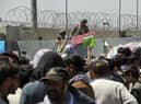 Hundreds of people gathering near an evacuation control checkpoint on the perimeter of the Hamid Karzai International Airport, in Kabul, Afghanistan, in August. Not everyone entitled to resettlement made it out of the country in time (AP Photo/Wali Sabawoon, File)